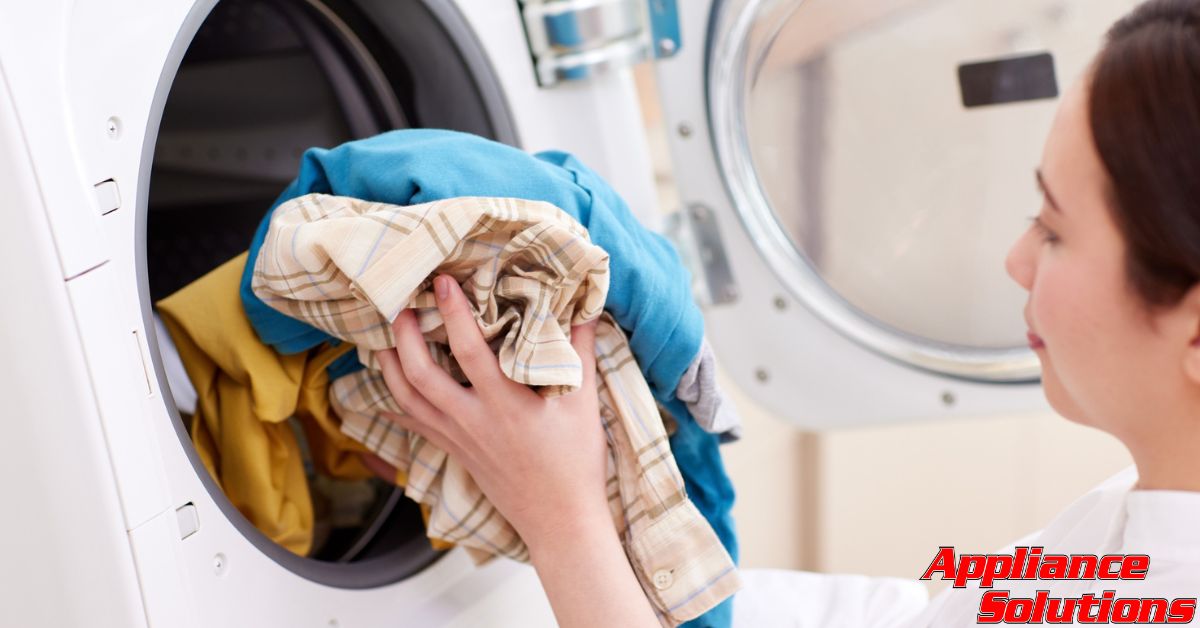 woman placing clothes into a dryer - Appliance Solutions dryer repair
