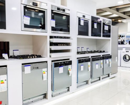 line of up stainless steel appliances in a store - Appliance Solutions reconditioned appliances