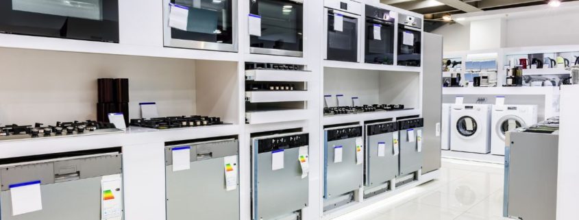 line of up stainless steel appliances in a store - Appliance Solutions reconditioned appliances