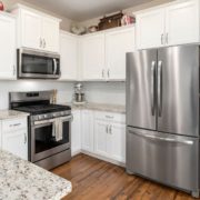 kitchen with white cabinets and stainless steel appliances - Appliance Solutions scratch and dent refrigerator