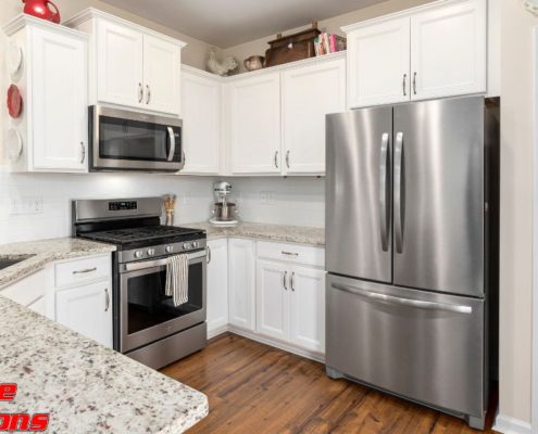 kitchen with white cabinets and stainless steel appliances - Appliance Solutions scratch and dent refrigerator