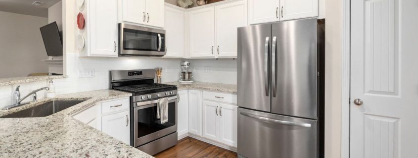 kitchen with white cabinets and stainless steel appliances - Appliance Solutions scratch and dent refrigerator